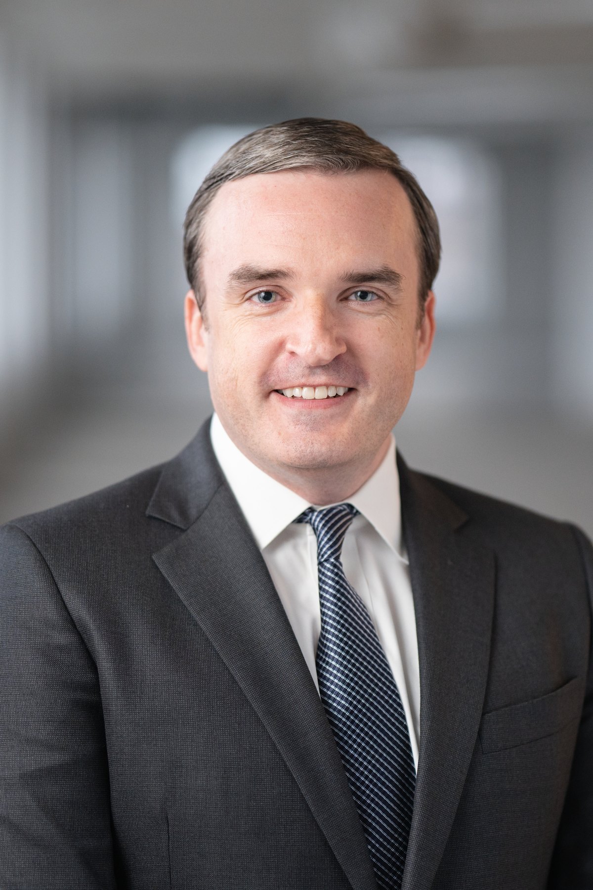Corporate headshot with the office softened behind the subject