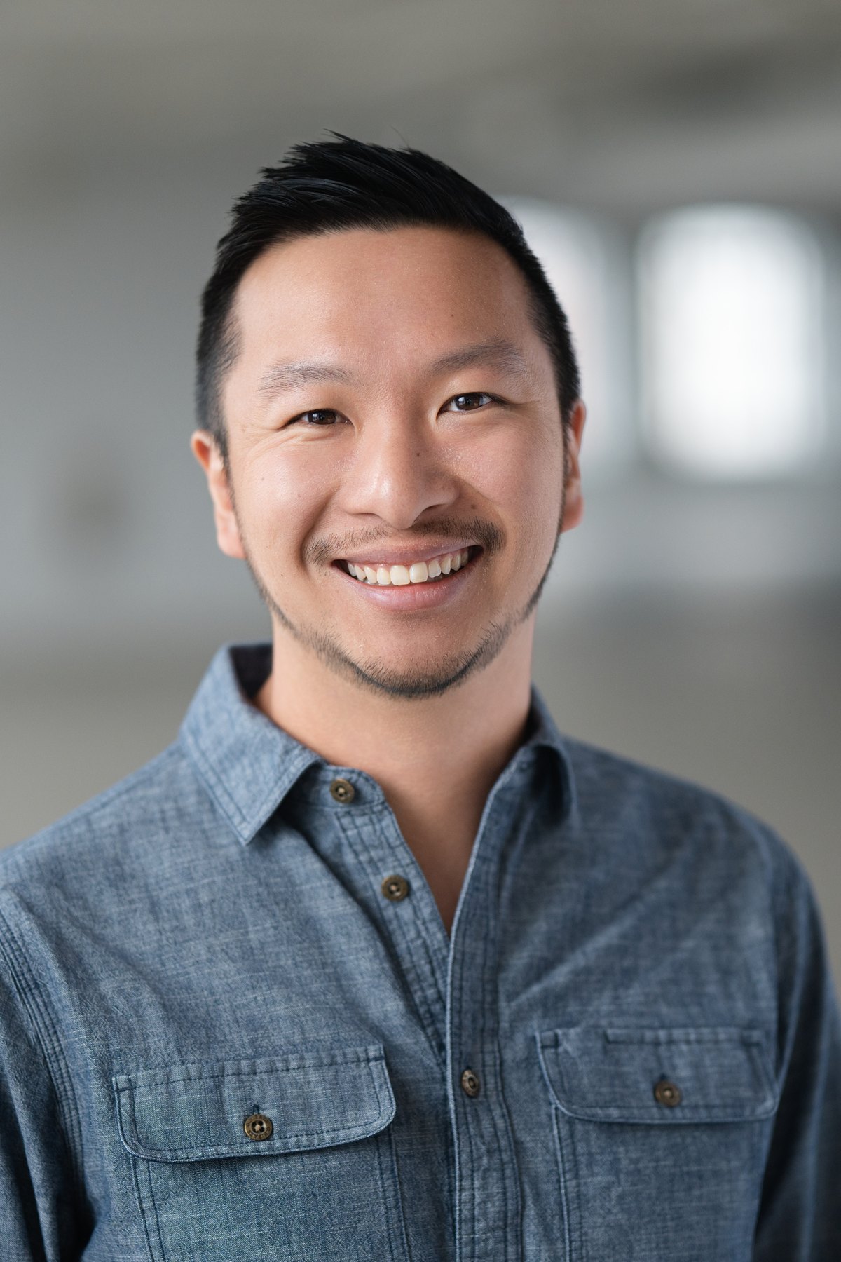 Corporate headshot with the office softened behind the subject