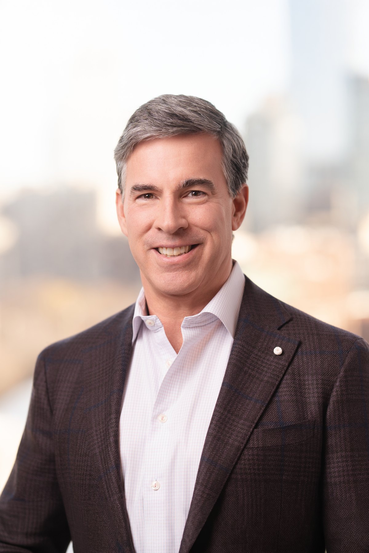 Corporate headshot with the city view softened through the window