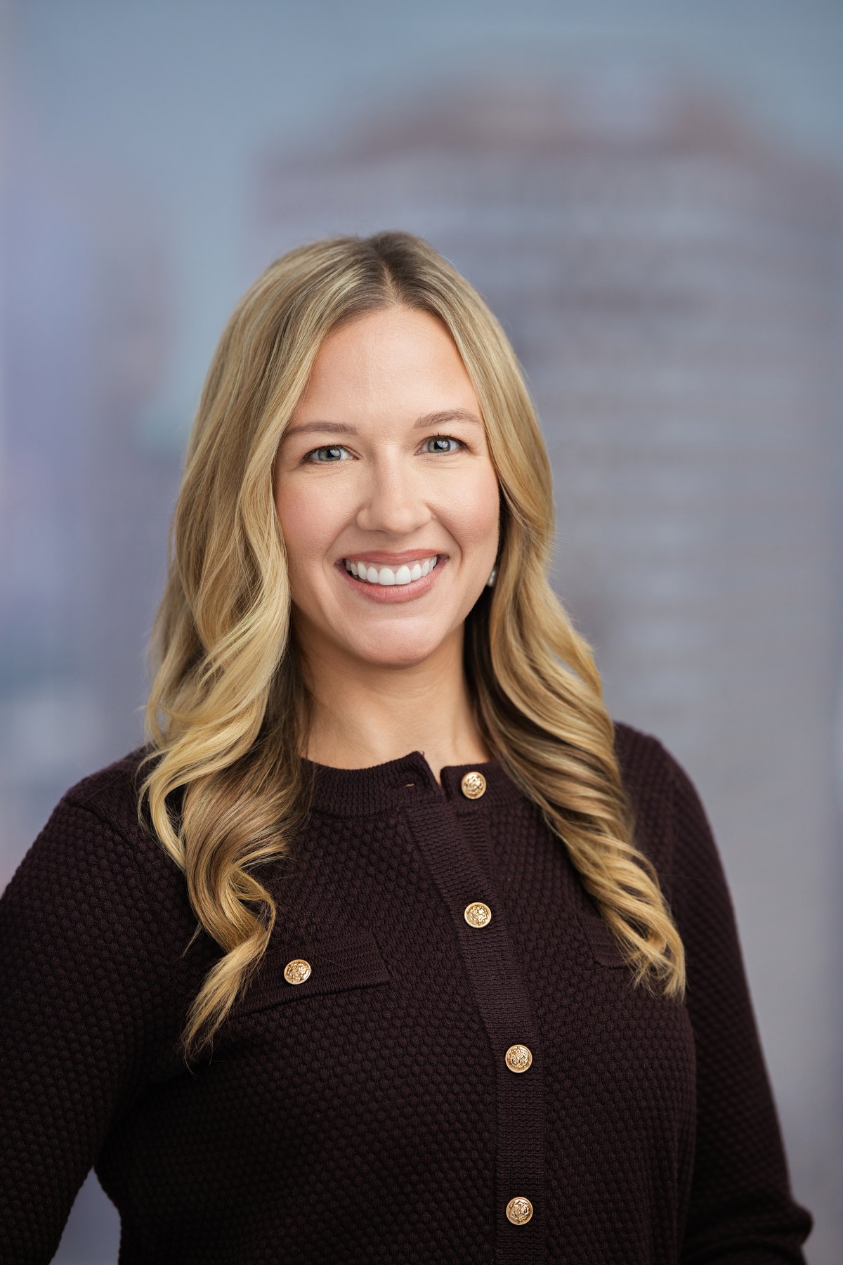 Corporate headshot with the city view softened through the window