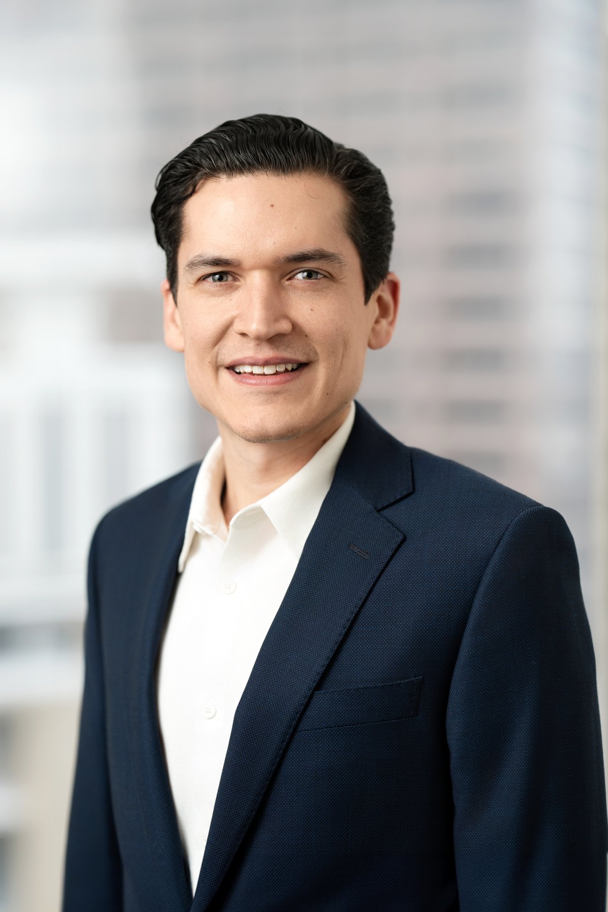 Corporate headshot with the city view softened through the window