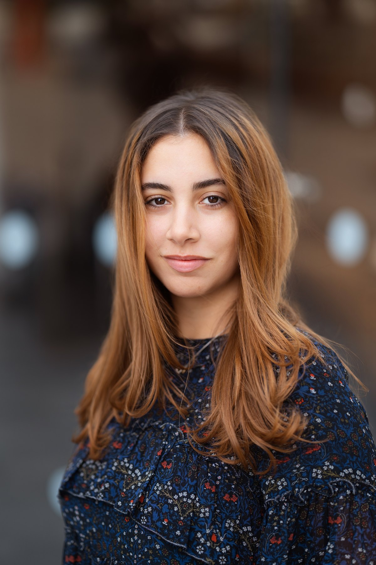 Corporate headshot with the city view softened through the window